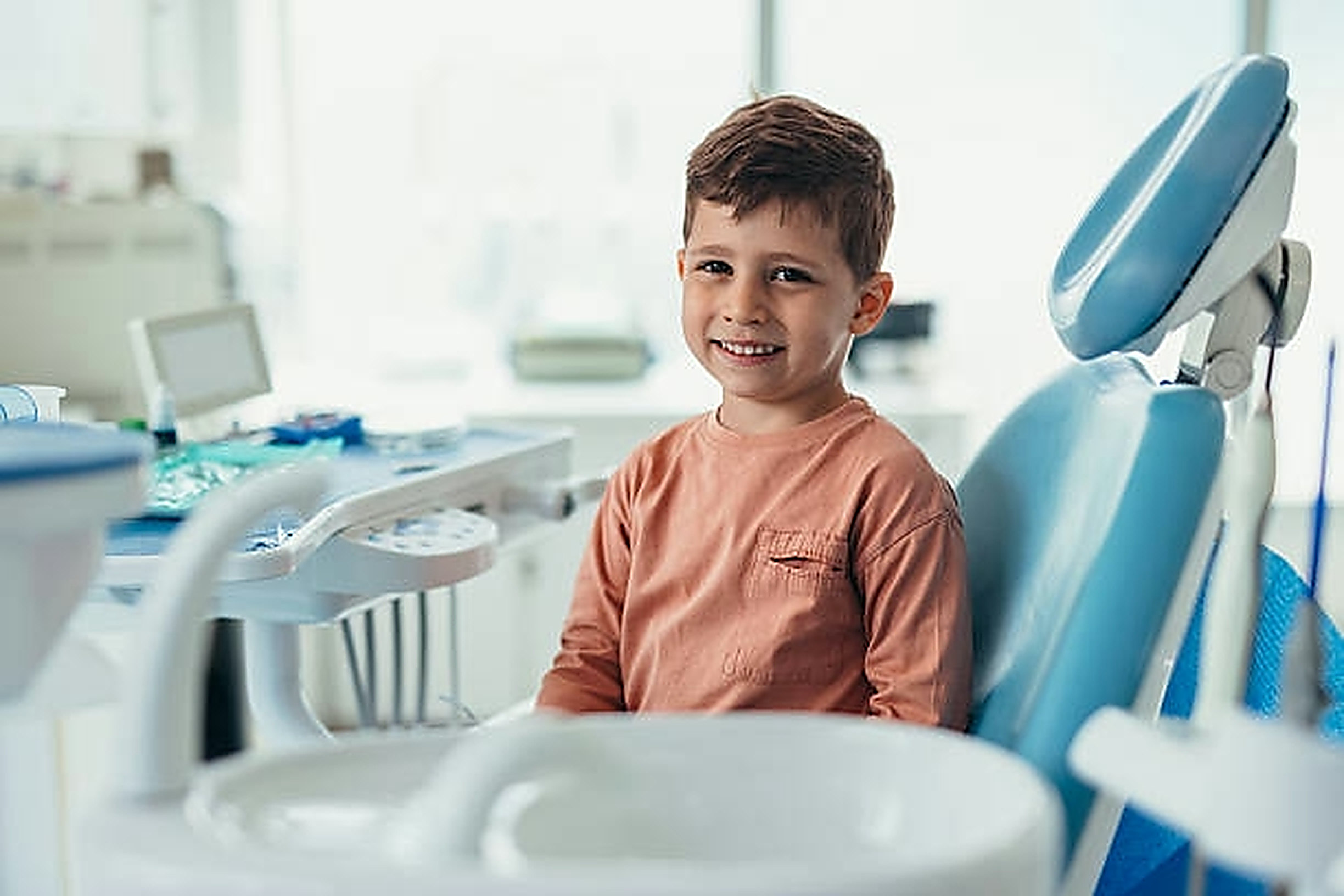 Niño sonriendo en el sillón dental de Clínicas O
